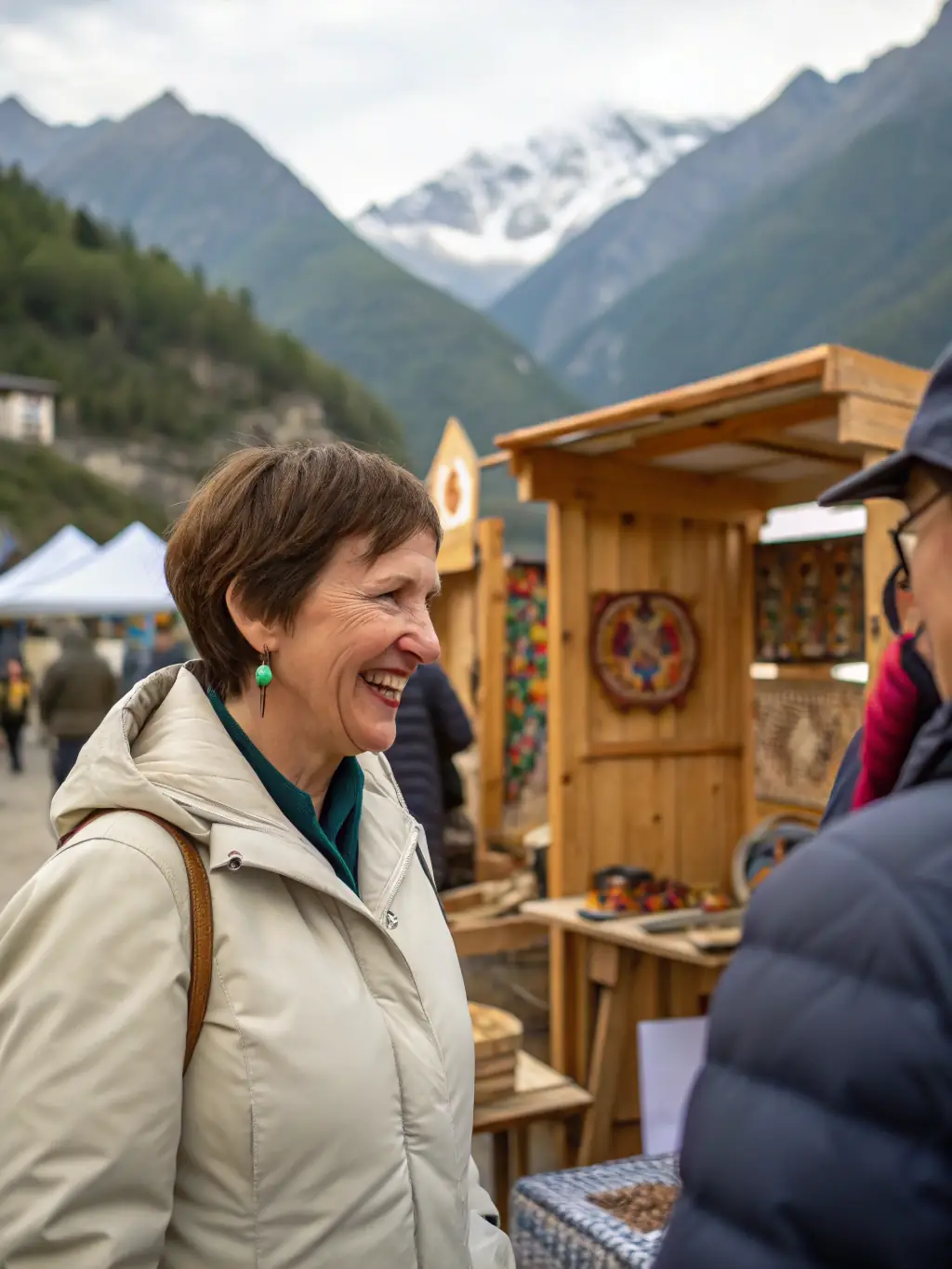 A local artisan displaying their unique embroidery creations at a market supported by La Grande Brodee, demonstrating the organization's commitment to cultural entrepreneurship. The artisan is smiling and engaging with customers.
